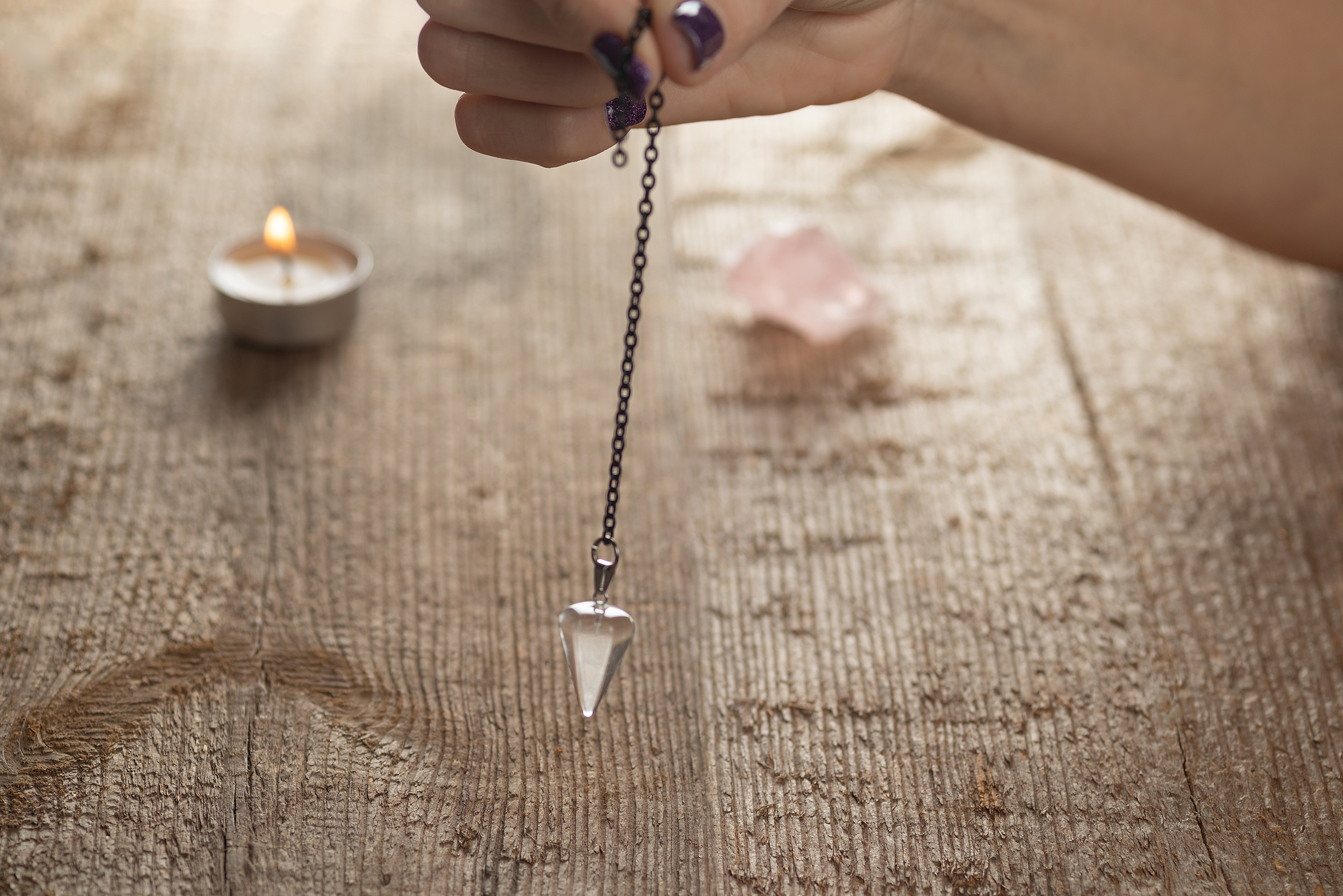 Hand Holding Pendulum for Divination and Dowsing